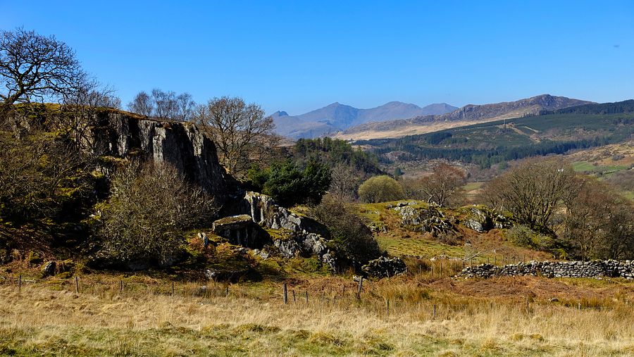 Rock face & Yr Wyddfa mountains from woodland path